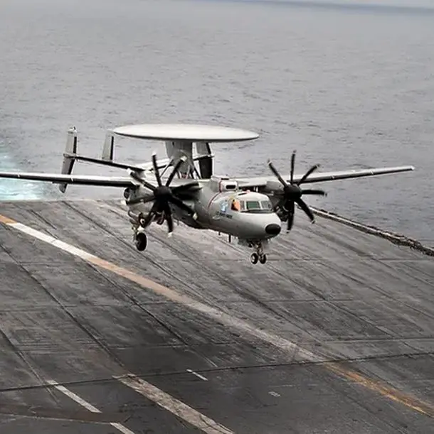 A plane is flying low over the water.